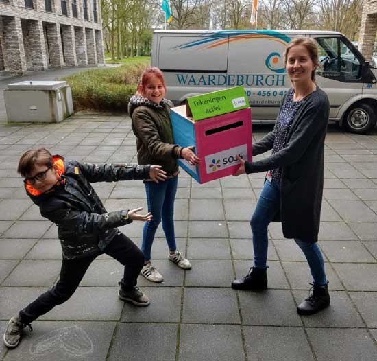 Kinder raadsleden delen tekeningen uit